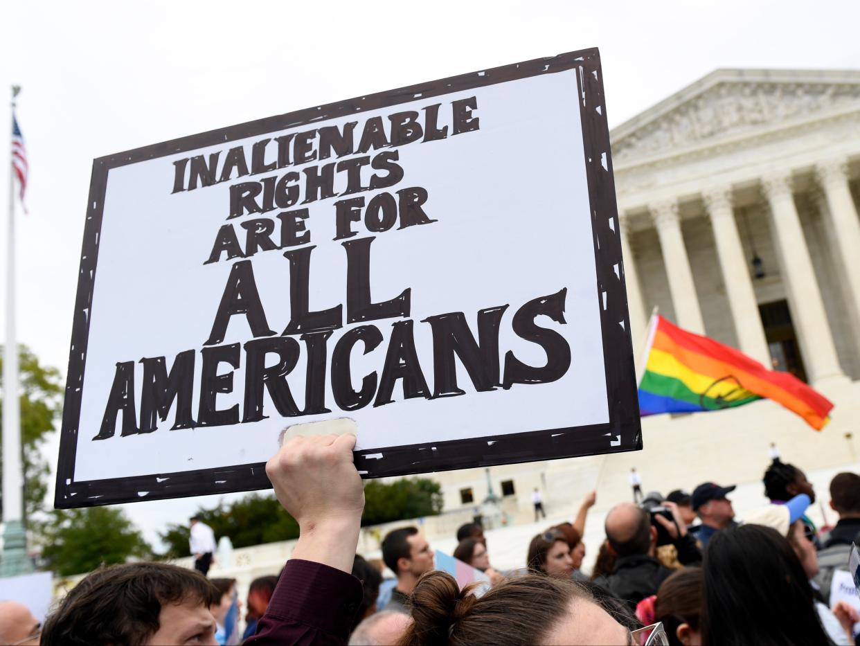 In this 8 October 2019, file photo, protesters gather outside the Supreme Court in Washington where the Supreme Court is hearing arguments in the first case of LGBT+ rights since the retirement of Supreme Court Justice Anthony Kennedy ((Associated Press))