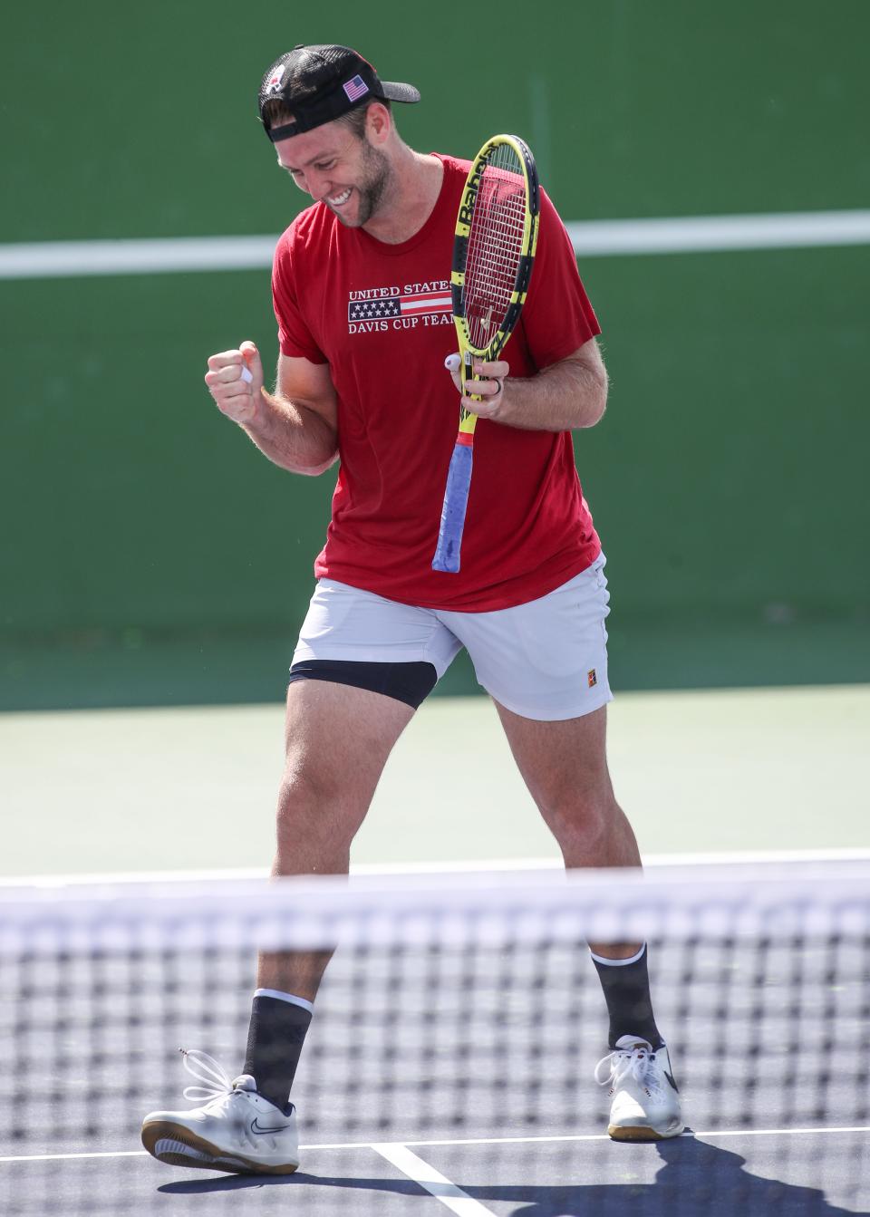 Jack Sock celebrates a successful lob shot against John Isner while the two practiced at the BNP Paribas Open in Indian Wells, October 6, 2021.