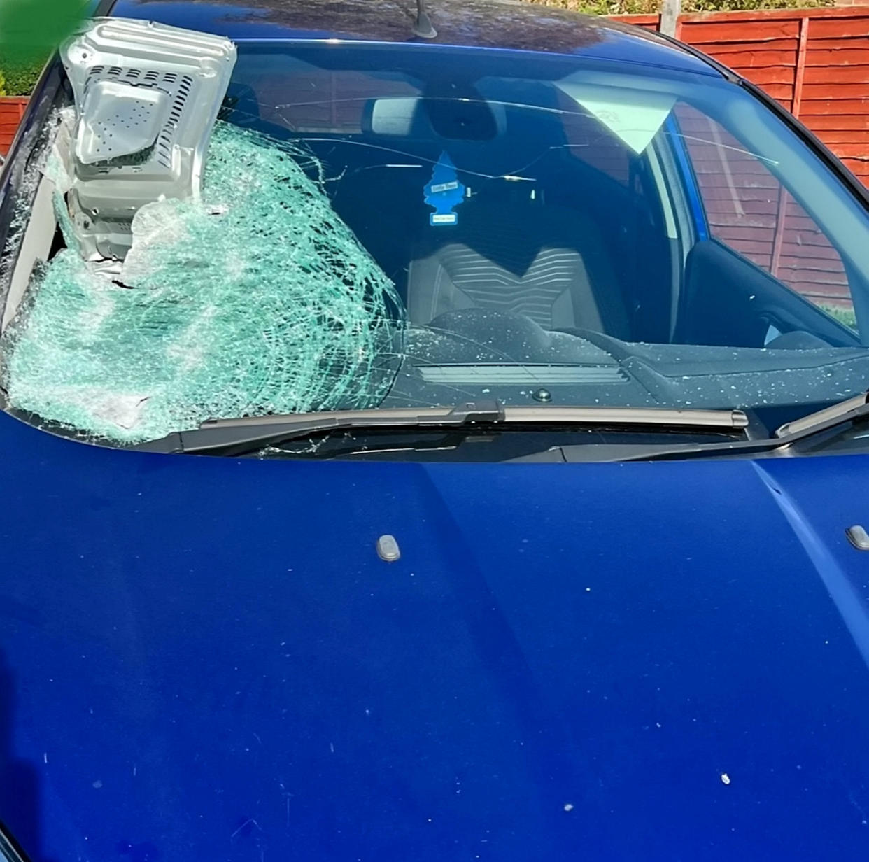 Two people on a moped who hurled a microwave at the windscreen of the oncoming car are being hunted. (SWNS)

 