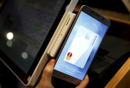 An employee demonstrates Samsung Pay, Samsung's new mobile payment system, at a shop in Seoul, South Korea, September 4, 2015. REUTERS/Kim Hong-Ji/File Photo