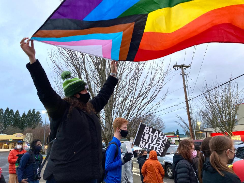 Annette Smith, a 4J alum and community member, waves a pride flag at a rally against hate speech in schools on Dec. 15, 2021 in north Eugene.