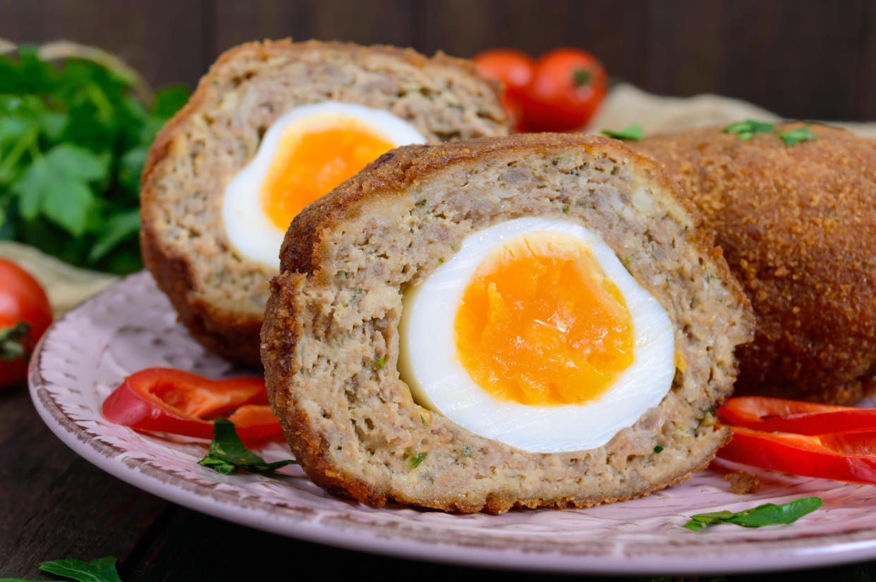 Large juicy cutlets stuffed with boiled egg on a dark wooden background. Scottish cutlet.