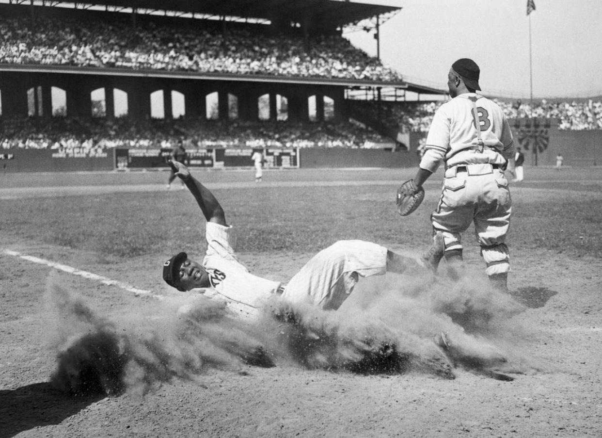 <span class="caption">Josh Gibson slides into home during the 1944 Negro Leagues All-Star Game.</span> <span class="attribution"><a class="link " href="https://www.gettyimages.com/detail/news-photo/josh-gibson-of-the-east-team-creates-a-cloud-of-dust-as-he-news-photo/514700378?adppopup=true" rel="nofollow noopener" target="_blank" data-ylk="slk:Bettmann/Getty Images;elm:context_link;itc:0;sec:content-canvas">Bettmann/Getty Images</a></span>