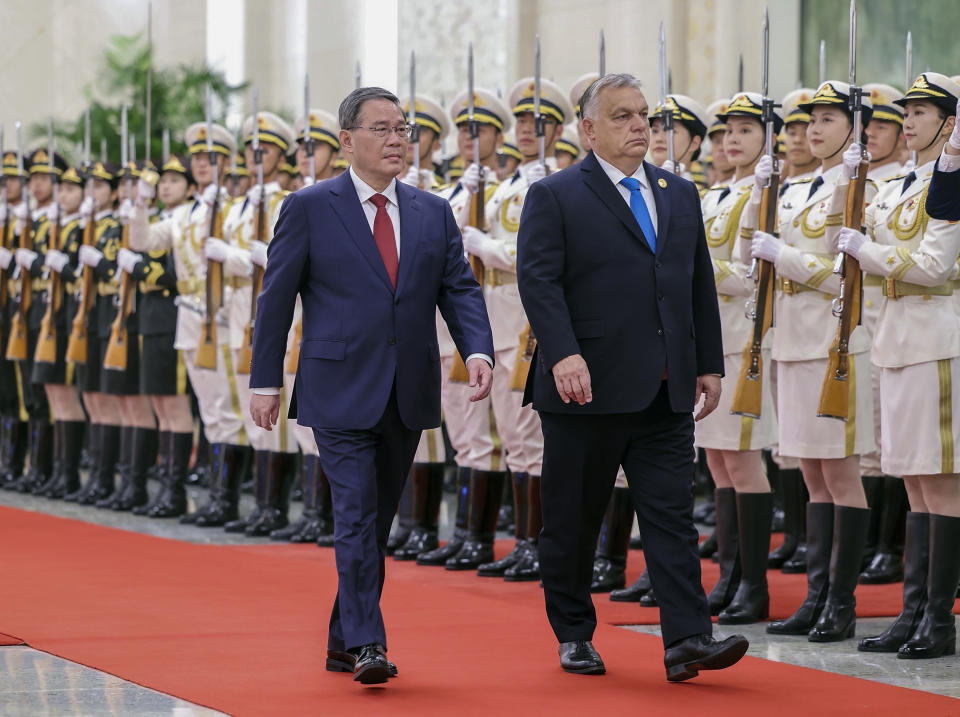 FILE- In this photo released by Xinhua News Agency, visiting Hungarian Prime Minister Viktor Orban, right, and his Chinese counterpart Li Qiang review an honor guard during a welcome ceremony at the Great Hall of the People in Beijing, on Oct. 16, 2023. Hungarian Prime Minister Viktor Orban is the only head of state or government from the European Union to attend the Belt and Road forum. Hungarian media reports last month suggested a Chinese-backed railway project connecting Budapest with Belgrade has hit snags and China would halt funding. (Liu Bin/Xinhua via AP, File)