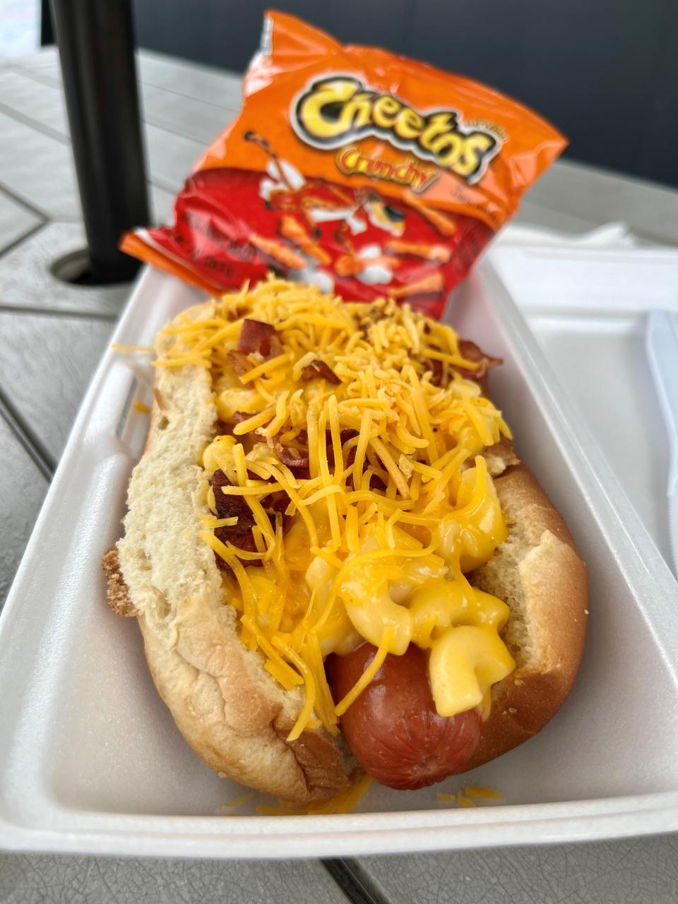 The mac & cheese dog with bacon is served with a knife and fork at Bimini Bites Home of The Flying Dog.