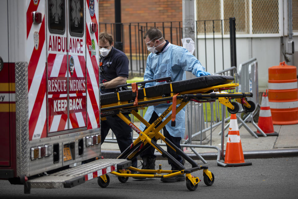 Two members of the Emergency Medical Team of the Fire Department of New York prepare their gurney before going on another ambulance call at the Elmhurst Hospital Center in the Queens borough of New York City on March 30, 2020. (Photo: Robert Nickelsberg/Getty Images)