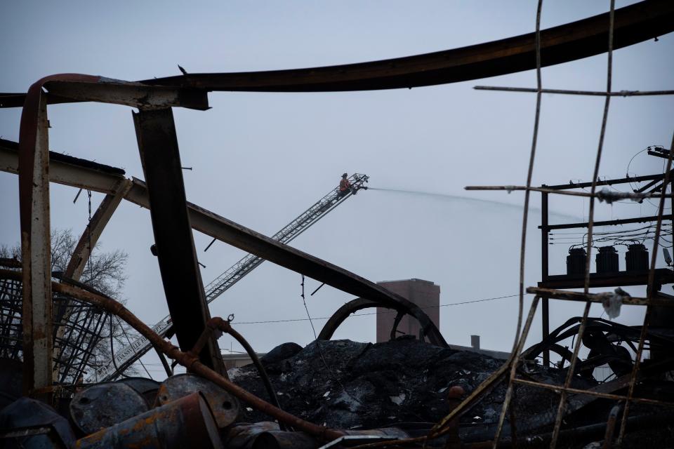 Evansville Fire Department personnel continue to put water on the hot spots Monday afternoon at a four-alarm fire that broke out in a warehouse in the 1400 block of North Garvin Street Saturday morning, Dec. 31, 2022. 