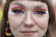 A reveler with rainbow coloured eye shadow, takes part in the Christopher Street Day (CSD) parade, in Berlin, Saturday, July 24, 2021. The official motto of the CSD is "Save our Community - save our Pride". (J'rg Carstensen/dpa via AP)