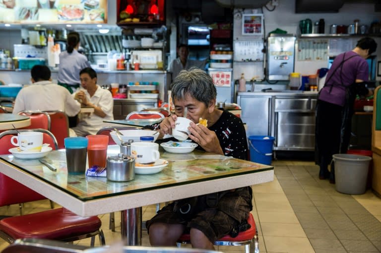 Au Fung-lan takes a break from her exhausting work to eat breakfast at a cafe in central Hong Kong