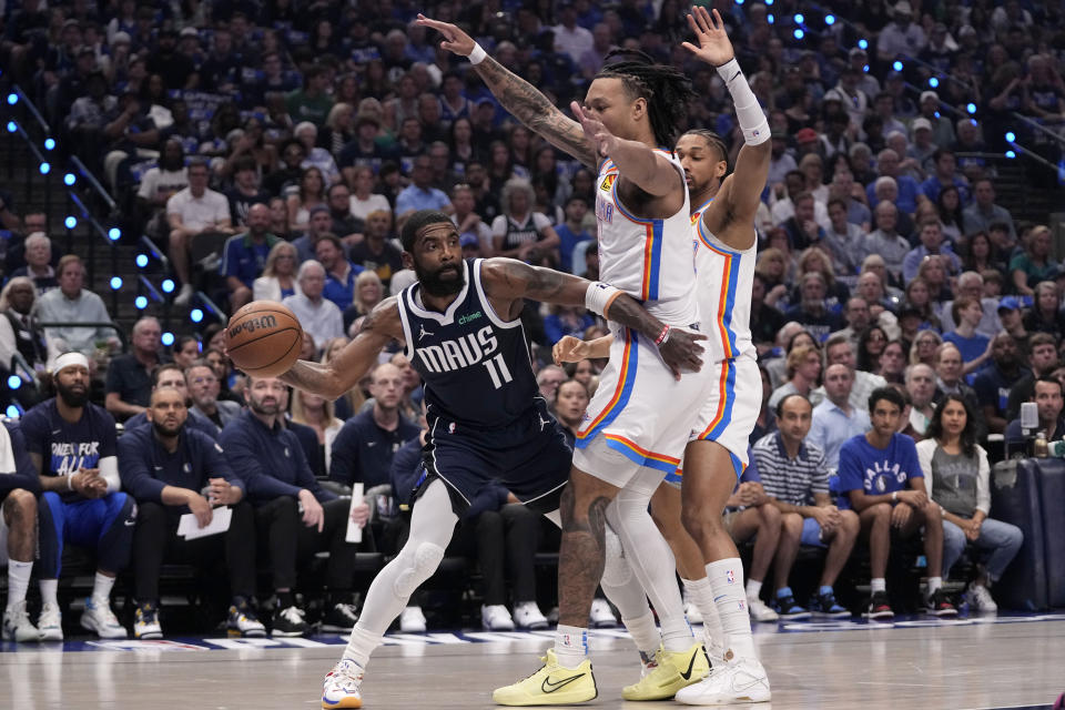 Dallas Mavericks guard Kyrie Irving (11) attempts to make a pass around Oklahoma City Thunder forward Jaylin Williams, right, during the first half in Game 3 of an NBA basketball second-round playoff series, Saturday, May 11, 2024, in Dallas. (AP Photo/Tony Gutierrez)