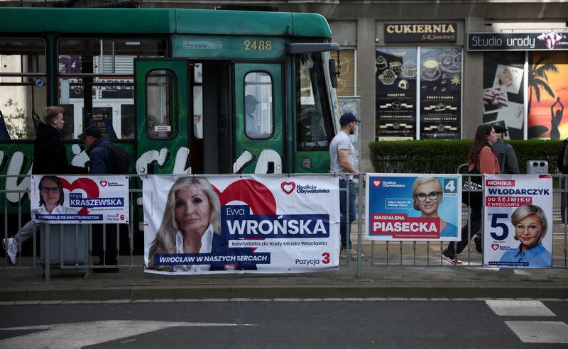 FILE PHOTO: People walk next to election posters ahead Polish local elections, in Wroclaw