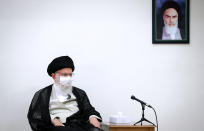 In this picture released by an official website of the office of the Iranian supreme leader on June 31, 2020, Supreme Leader Ayatollah Ali Khamenei wears a protective face mask to help prevent to spread of the coronavirus while sitting under a portrait of the late revolutionary founder Ayatollah Khomeini during a meeting in Tehran, Iran. Iran on Sunday instituted mandatory mask-wearing as fears mount over newly spiking reported deaths from the coronavirus, even as its public increasingly shrugs off the danger of the COVID-19 illness it causes. Khamenei has publicized an image of himself in a mask in recent days, urging both public officials and the Islamic Republic's 80 million people to wear them to stop the virus's spread. (Office of the Iranian Supreme Leader via AP)