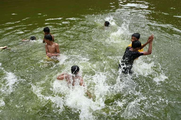 Unos niños se bañan en un estanque para refrescarse a causa de la ola de calor, el 17 de abril de 2024 en Daca, la capital de Bangladés (Munir Uz Zaman)