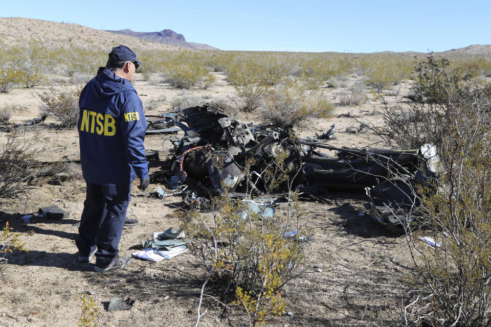 FILE - In this photo provided by the National Transportation Safety Board, an NTSB investigator surveys the site of an Airbus Helicopters EC-130 on Sunday, Feb. 11, 2024, near Halloran Springs, Calif. The family of a Nigerian business leader who died in the Southern California helicopter crash that killed five others filed a lawsuit Wednesday, April 10, claiming the flight should have been grounded because of treacherous weather. (Peter Knudson/National Transportation Safety Board via AP, File)