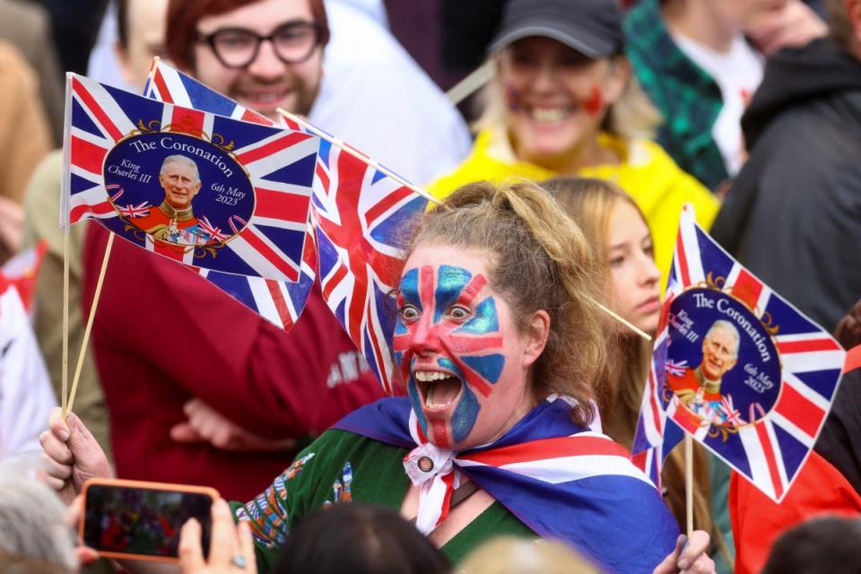 A royal fan celebrates the coronation outside the Mall (REUTERS)