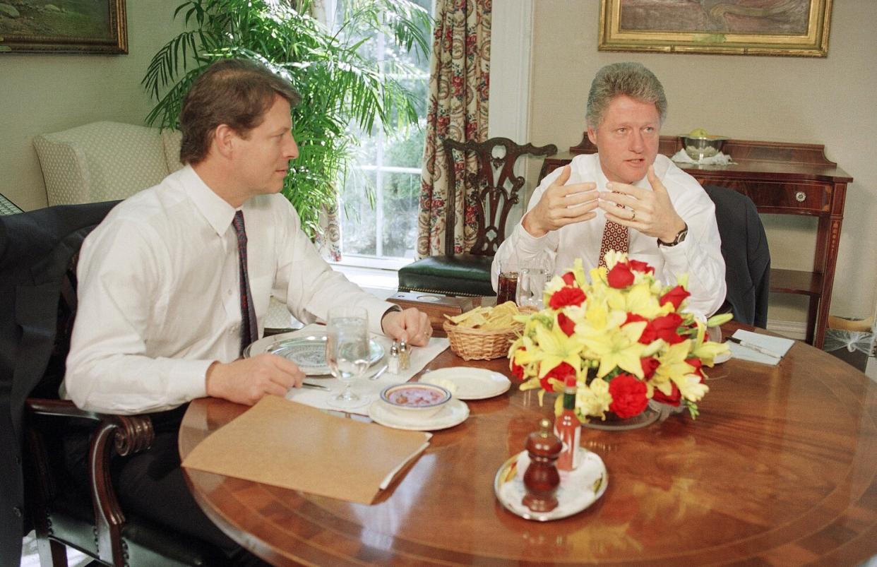 President Clinton gestures as he sits at a lunch table with Vice President Al Gore.