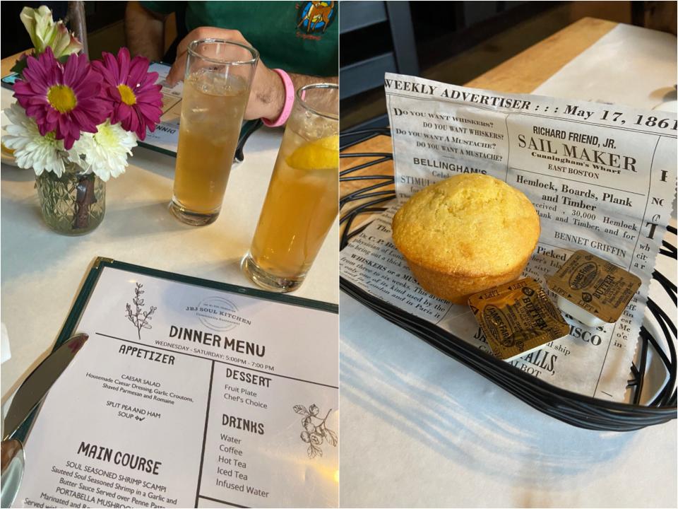 Side by side of the table with a menu, a small bouquet of pink and white flowers, and ice tea glasses next to a basket with newspaper under a corn muffin and butter.