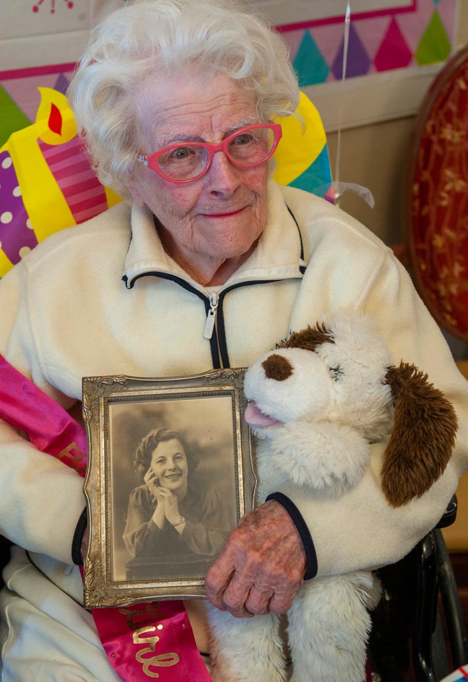 Agnes DeCenzo holds a photo of her younger self as she basks in the attention given to her during her 105th birthday, Feb. 15, 2023.