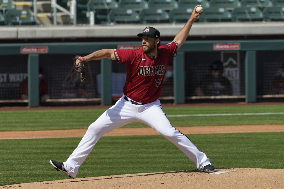 El pitcher Madison Bumgarner de los Diamondbacks de Arizona lanza ante los Angelinos de Los Ángeles, en un juego de pretemporada, en Scottsdale, Arizona, el jueves 4 de marzo de 2021. (AP Foto/Matt York)