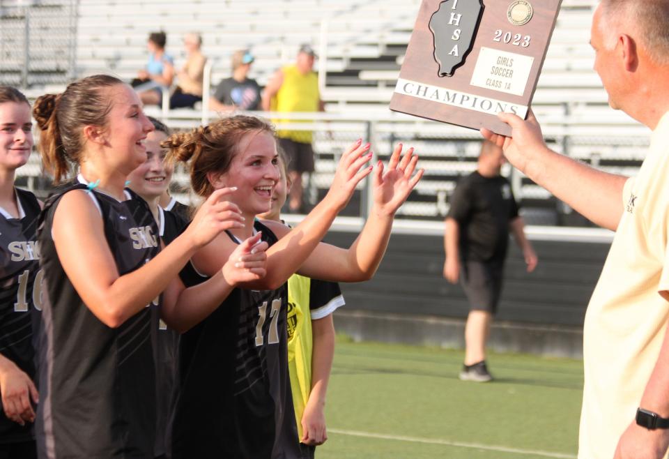 Sacred Heart-Griffin's Hannah Lambert (17) receives the Class 1A regional plaque after the Cyclones defeated Quincy Notre Dame 4-2 at Ken Leonard Field on Friday, May 12, 2023.