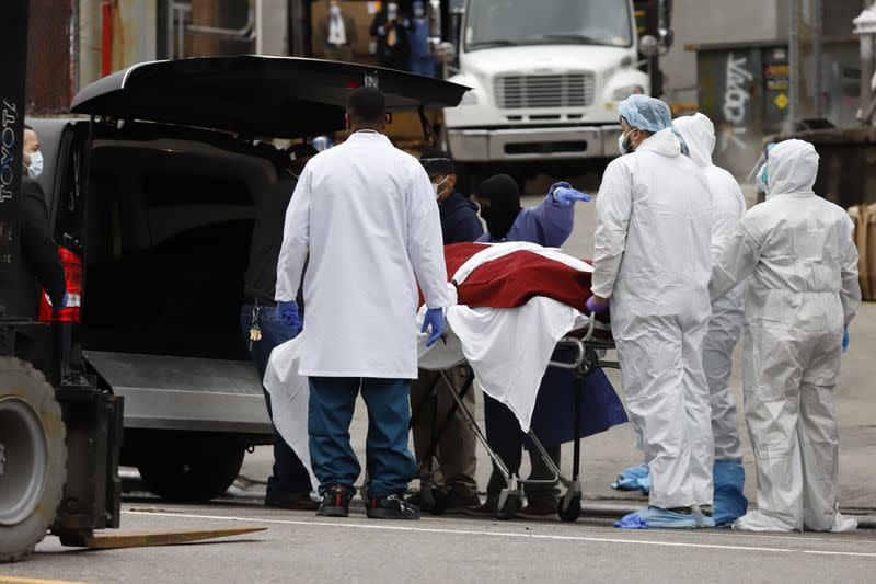 Workers load deceased person into a waiting hearse outside Brooklyn Hospital Center during the coronavirus disease (COVID-19) in New York