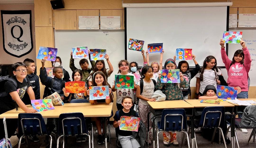 A Tools For Tomorrow class at Ronald Reagan Elementary School proudly display their paintings.
