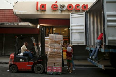 Workers unload products from a truck to a state-run shop in downtown Havana, April 12, 2016. REUTERS/Alexandre Meneghini