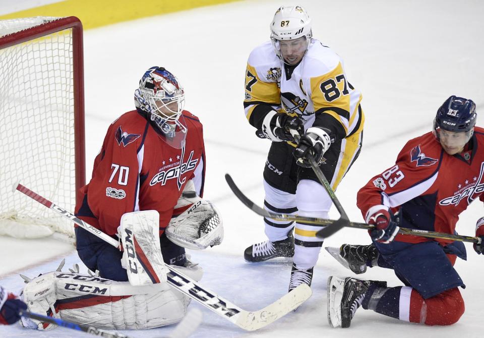 Washington Capitals goalie Braden Holtby (70) stops the puck against Pittsburgh Penguins center Sidney Crosby (87) during the second period of an NHL hockey game, Wednesday, Jan. 11, 2017, in Washington. Also seen is Washington Capitals center Jay Beagle (83). (AP Photo/Nick Wass)