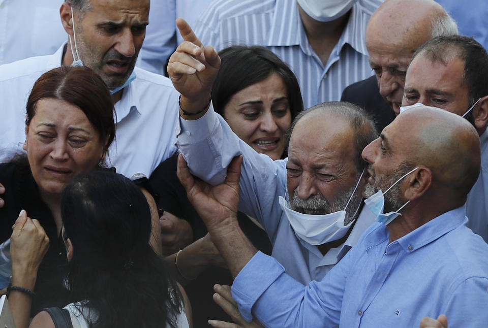 The father, center, of Charbel Karam, one of the ten firefighters who were killed during the Aug. 4 explosion that hit the seaport of Beirut, mourns during his son's funeral at the firefighter headquarters, in Beirut, Lebanon, Monday, Aug. 17, 2020. (AP Photo/Hussein Malla)