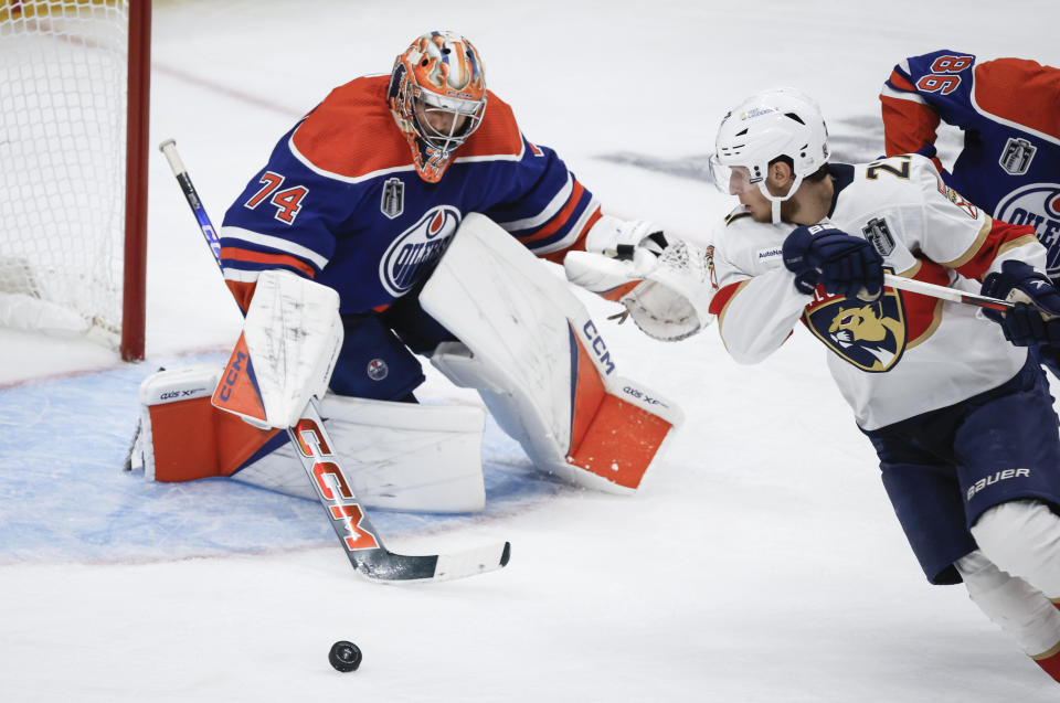 Florida Panthers' Eetu Luostarinen (27) tries to get to the puck as Edmonton Oilers goalie Stuart Skinner (74) guards the net during the third period of Game 4 of the NHL hockey Stanley Cup Final, Saturday, June 15, 2024, in Edmonton, Alberta. (Jeff McIntosh/The Canadian Press via AP)