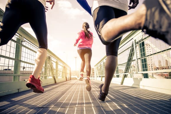 Three young people running outdoors.