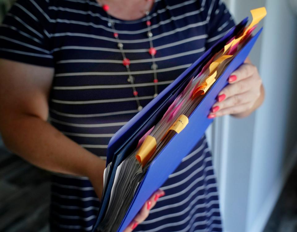 Kara Stamiris, 42, of Ypsilanti photographed Oct. 18 at her home. She keeps a binder tracking her efforts to find schooling for her nieces and nephew.