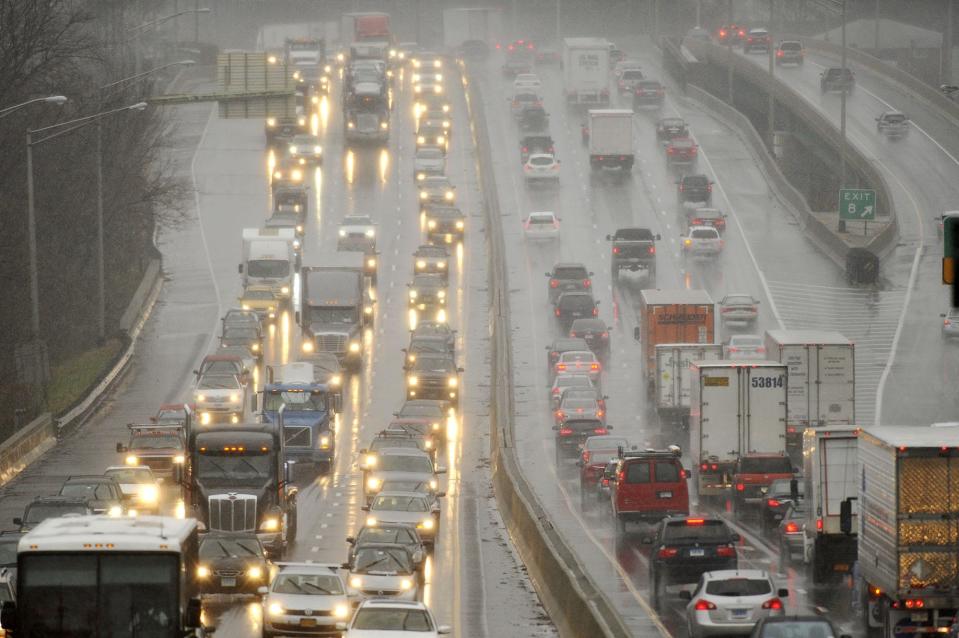 Traffic crawls along Interstate 95 as sleet falls during the beginning of a snowstorm in Connecticut on the day before Thanksgiving in 2014. More 'miserable' travel is expected Tuesday in the Mid-Atlantic, forecasters said.