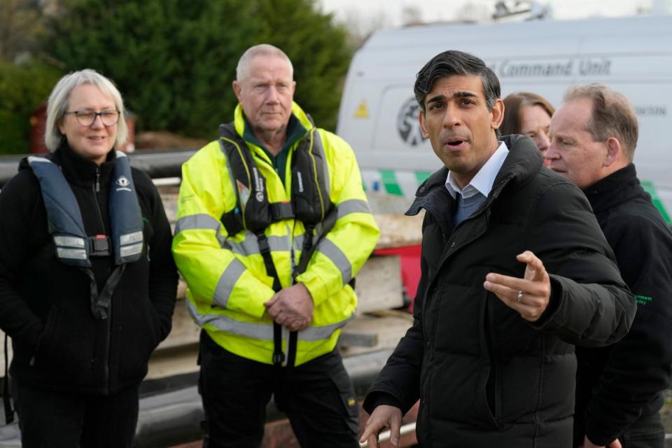 Prime Minister Rishi Sunak speaks to members of the Environment Agency as he looks at flood defences during a visit to Osney, Oxford (PA)