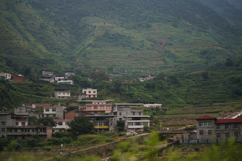 FILE PHOTO: Houses are seen at the foot of a mountain in Sichuan