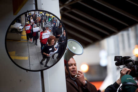 Interfaith clergy leaders are reflected in a mirror as they march from the Center City Starbucks, where two black men were arrested, to other nearby stores in Philadelphia, Pennsylvania U.S. April 16, 2018. REUTERS/Mark Makela