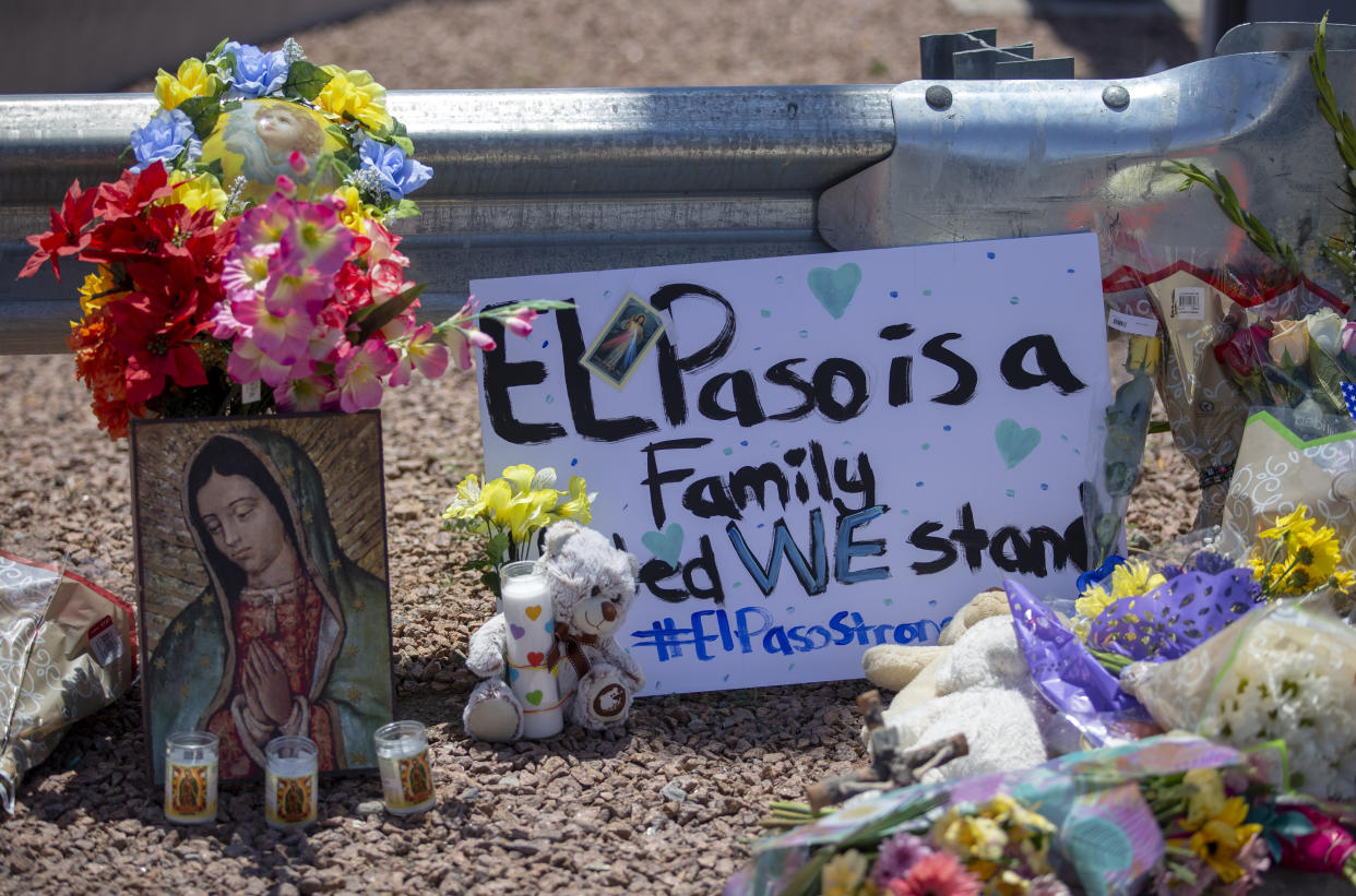 Unas flores y una imagen de la Virgen de Guadalupe adornan un monumento conmemorativo improvisado en honor de las víctimas de un tiroteo en un centro comercial en El Paso, Texas, el domingo 4 de agosto de 2019. El letrero dice: "El Paso es una familia. Permanecemos unidos". (AP Foto/Andrés Leighton)