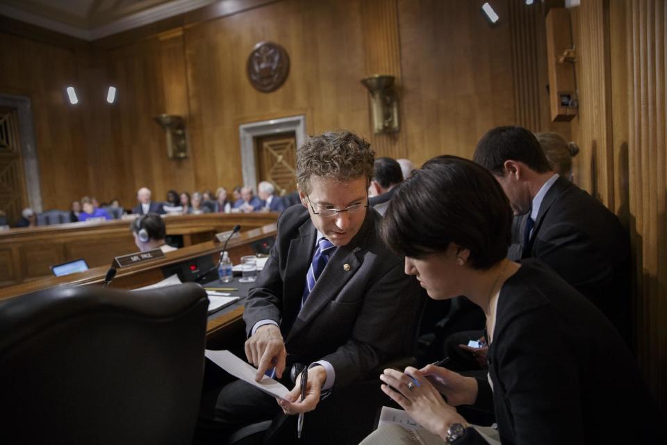 Sen. Rand Paul, R-Ky., confers with an aide as the Senate Foreign Relations Committee drafts legislation that would show support for the people of Ukraine and send a get-tough message to Russian President Vladimir Putin for taking over the Crimea region, on Capitol Hill in Washington, Wednesday, March 12, 2014. The committee was set to meet with acting Ukrainian Prime Minister Arseniy Yatseniuk later. (AP Photo/J. Scott Applewhite)