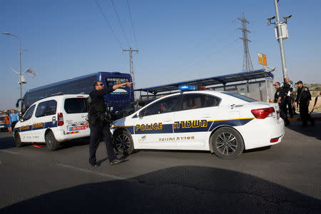 An Israeli policeman gestures at the scene of a Palestinian car ramming attack at the Gush Etzion Junction, south of the West Bank city of Bethlehem April 19, 2017. REUTERS/Mussa Qawasma