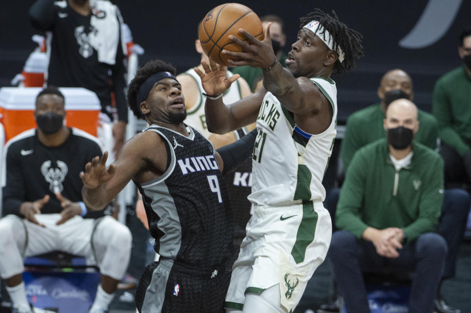 Sacramento Kings guard Terrence Davis (9) defends against Milwaukee Bucks guard Jrue Holiday (21) during the second half of an NBA basketball game in Sacramento, Calif., Saturday, April 3, 2021. The Bucks won 129-128. (AP Photo/Randall Benton)