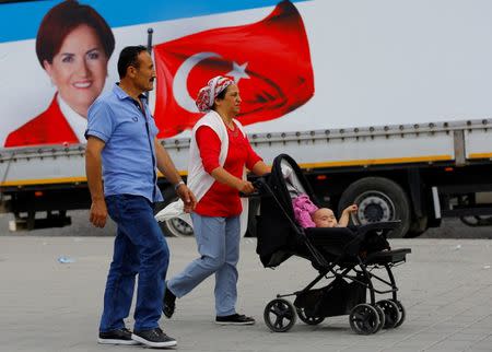 People walk past an election poster of Iyi (Good) Party leader Meral Aksener in Istanbul, Turkey, June 16, 2018. REUTERS/Huseyin Aldemir