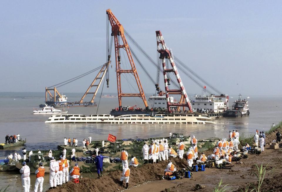 Rescuers look on as cranes work on righting the capsized Eastern Star cruise ship at the Jianli section of the Yangtze River