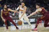 Phoenix Suns' Landry Shamet (14) drives between Cleveland Cavaliers' Cedi Osman (16) and Ricky Rubio (3) during the first half of an NBA basketball game Wednesday, Nov. 24, 2021, in Cleveland. (AP Photo/Tony Dejak)