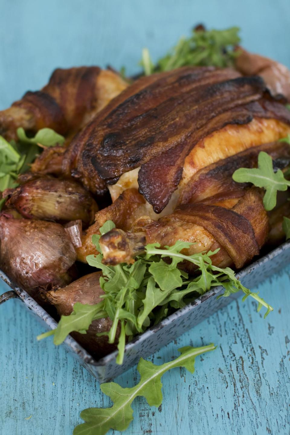 In this image taken on February 11, 2013, roasted chicken with 40 cloves of garlic and a bacon blanket is shown in Concord, N.H. (AP Photo/Matthew Mead)