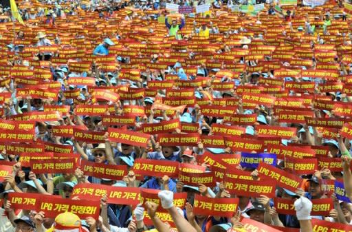 Thousands of South Korean taxi drivers wave red banners reading "price stabilization of LPG, used as an alternative fuel for most taxis," during a protest in Seoul on June 20, 2012. More than 200,000 South Korean taxi drivers staged a rare day-long strike for higher fares and cheaper fuel, prompting authorities to run extra bus and subway services