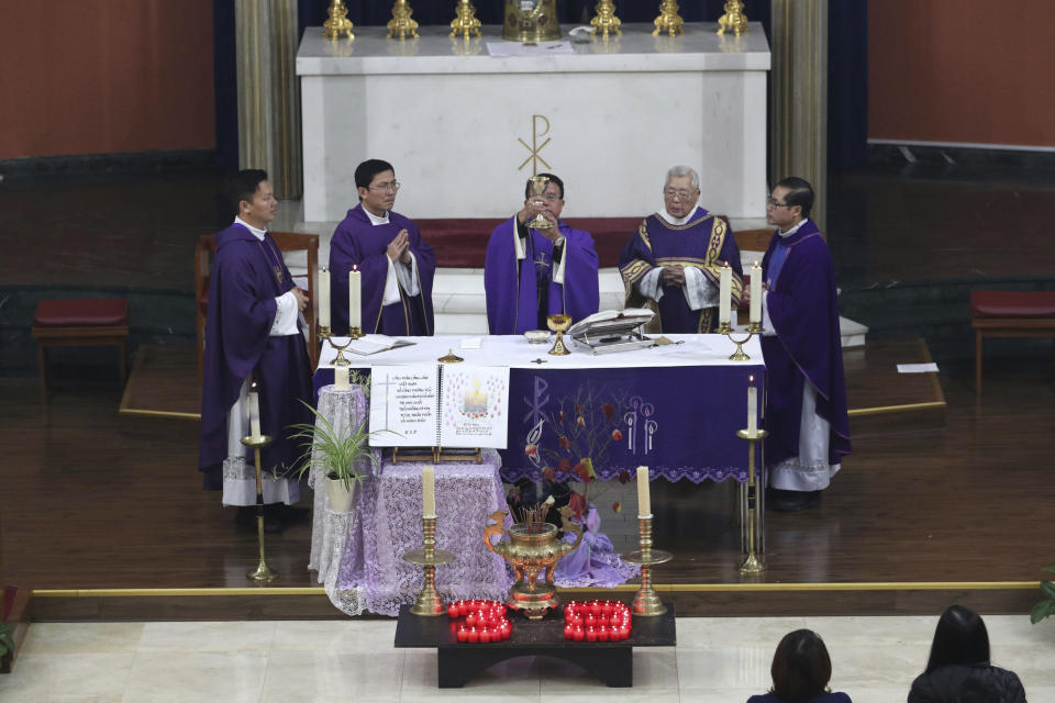 Father Simon Thang Duc Nguyen, center, leads the congregation during a Mass and vigil for the 39 victims found dead inside the back of a truck in Grays, Essex, at The Holy Name and Our Lady of the Sacred Heart Church, east London's Vietnamese church on Saturday, Nov. 2, 2019. All those killed were Vietnamese nationals, British police said. (Yui Mok/PA via AP)