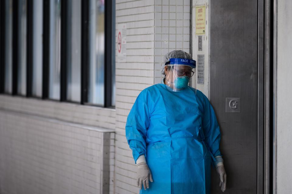 A medical worker wearing protective gear stands outside a lift in the grounds of Princess Margaret Hospital in Hong Kong on February 4, 2020. - Hong Kong on February 4 became the second place outside mainland China to report the death of a coronavirus patient as officials said they feared local transmissions were increasing in the densely populated city. (Photo by Anthony WALLACE / AFP) (Photo by ANTHONY WALLACE/AFP via Getty Images)