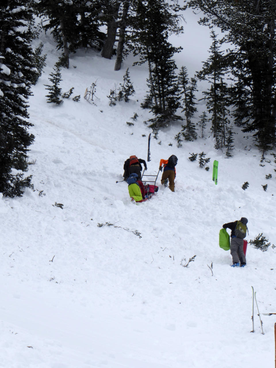 This aerial photo provided by Gallatin National Forest Avalanche Center shows a ground team approaching the area of an avalanche in the Gallatin National Forest, Mont., on Sunday, Feb. 14, 2021. A backcountry skier Craig Kitto, 45, of Bozeman, suffered fatal injuries when the Gallatin National Forest slope he and a companion were climbing cracked without warning, collapsed and swept him downhill into a tree. The other person wasn't hurt. (Gallatin National Forest Avalanche Center via AP)