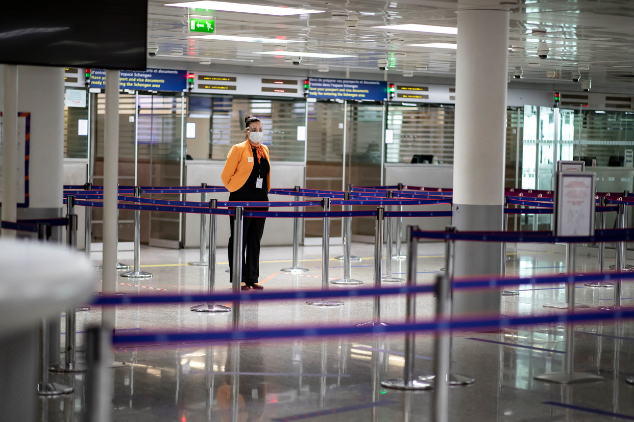 En esta foto de archivo tomada el 14 de mayo de 2020, un miembro del personal del aeropuerto Charles de Gaulle usa una máscara facial protectora en la sección de control de pasaportes desierta de las llegadas