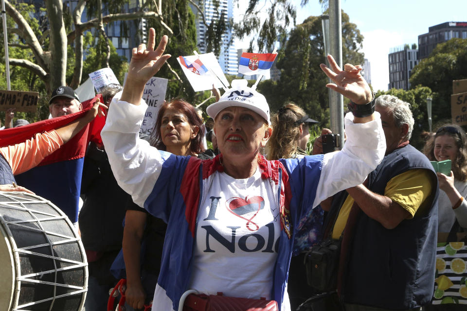 A protester and fan of Serbia's Novak Djokovic stands outside the Park Hotel, Australia, Saturday, Jan. 8, 2022. Djokovic has been confined to the detention hotel in Melbourne pending a court hearing on Monday, a week before the start of the Australian Open. He was barred from entering the country late Wednesday when federal border authorities at the Melbourne airport rejected his medical exemption to Australia's strict COVID-19 vaccination requirements. (AP Photo/Hamish Blair)